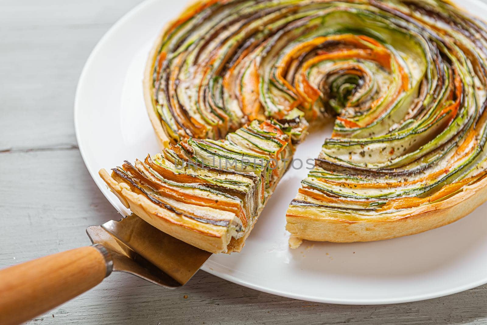 classic ratatouille pie on a light gray table. by vvmich