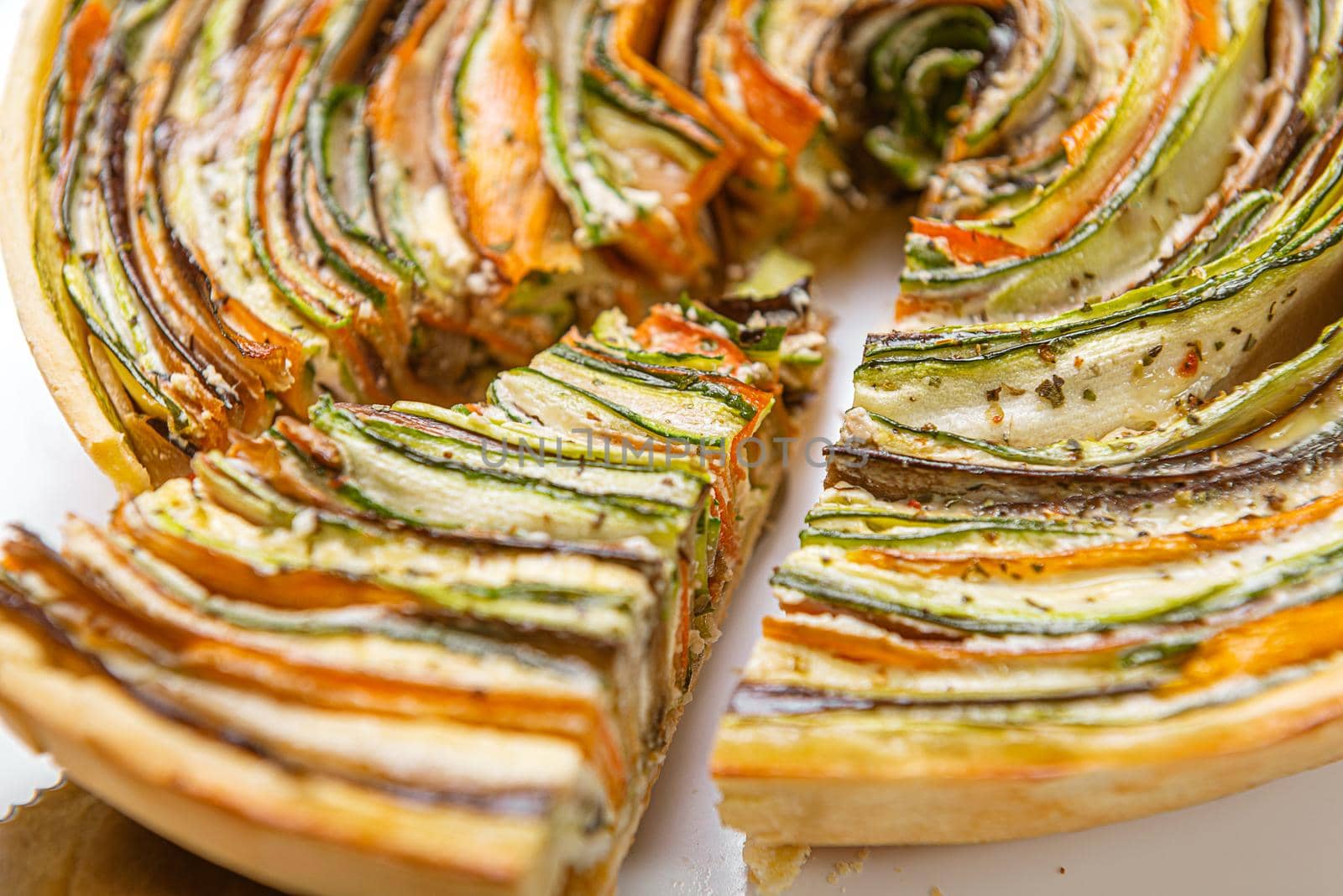 classic ratatouille pie on a light gray table. by vvmich