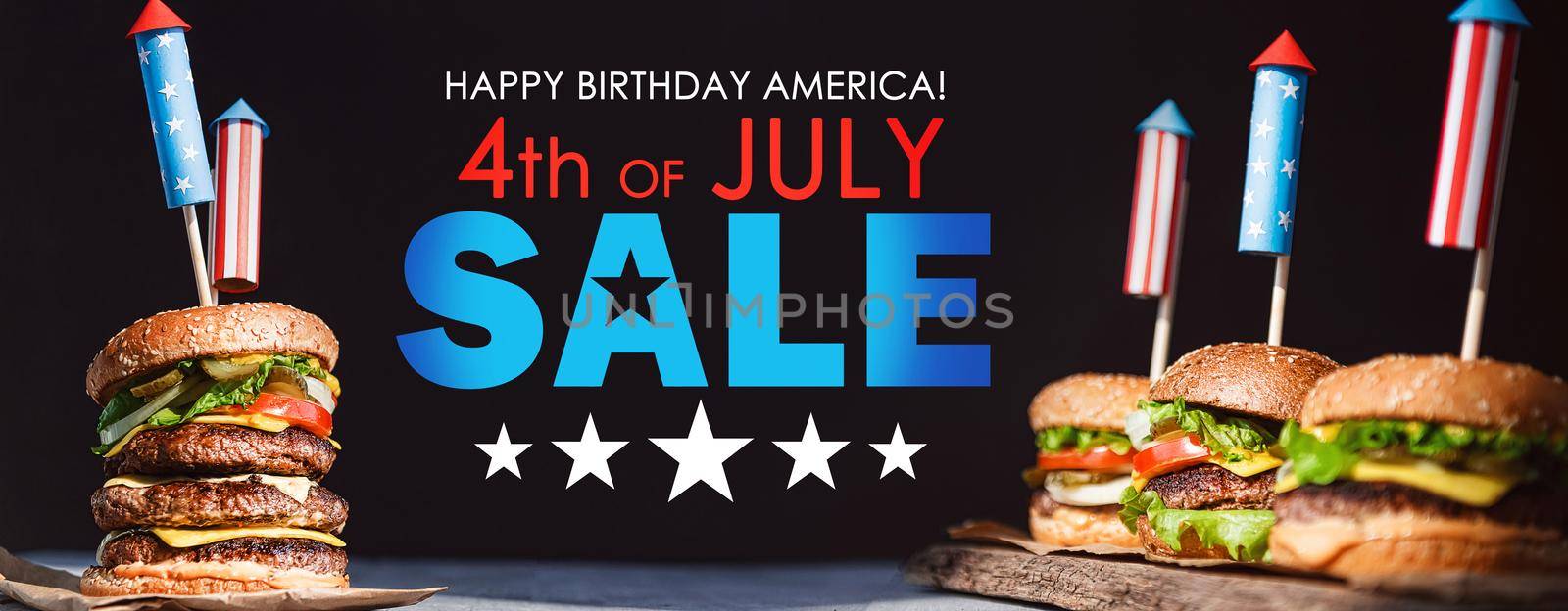 three fresh and juicy burgers with American flag-style fireworks inserted into them. bbq concept picnic to celebrate independence day by vvmich