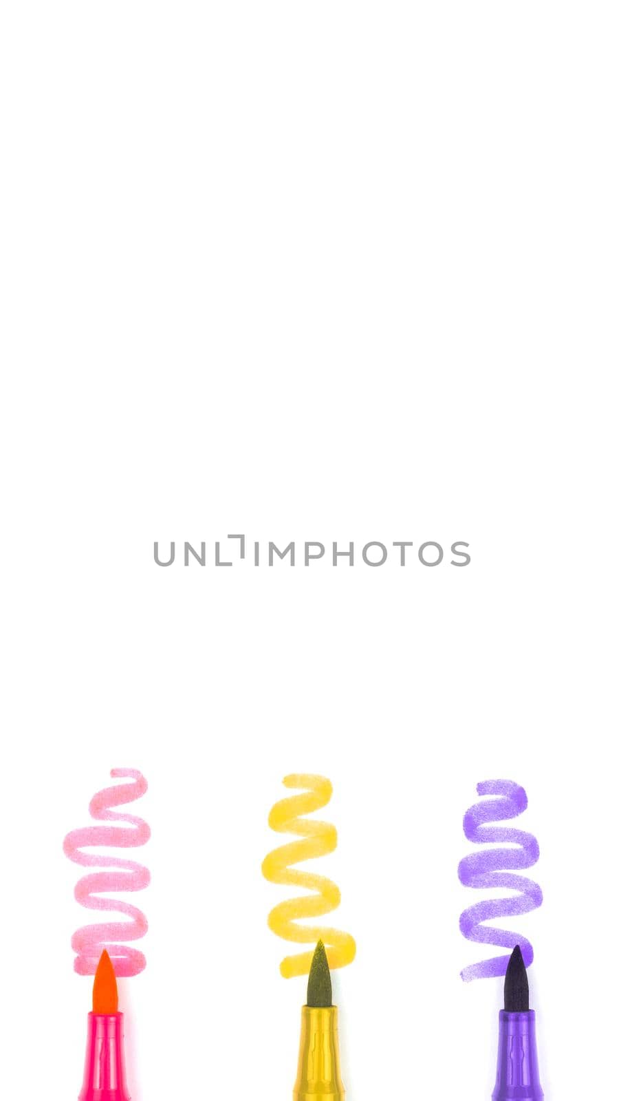 Three multicolored markers on a white background with copy space.