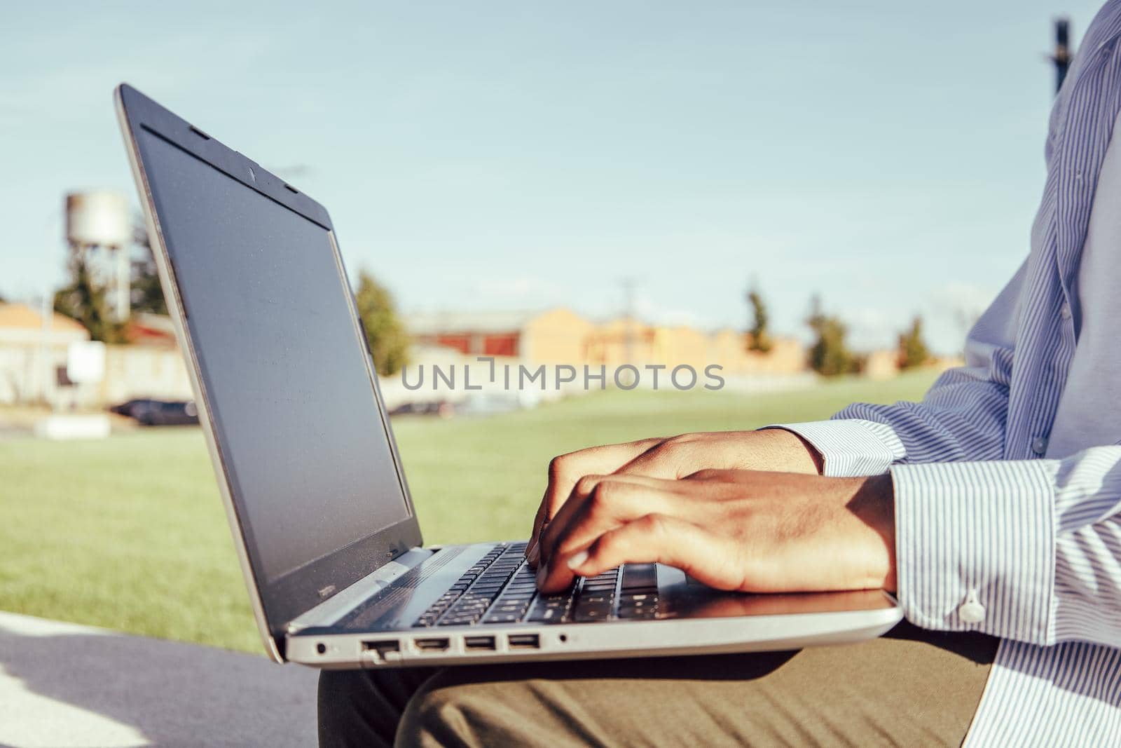 Close up of afro american hands typing on laptop on park