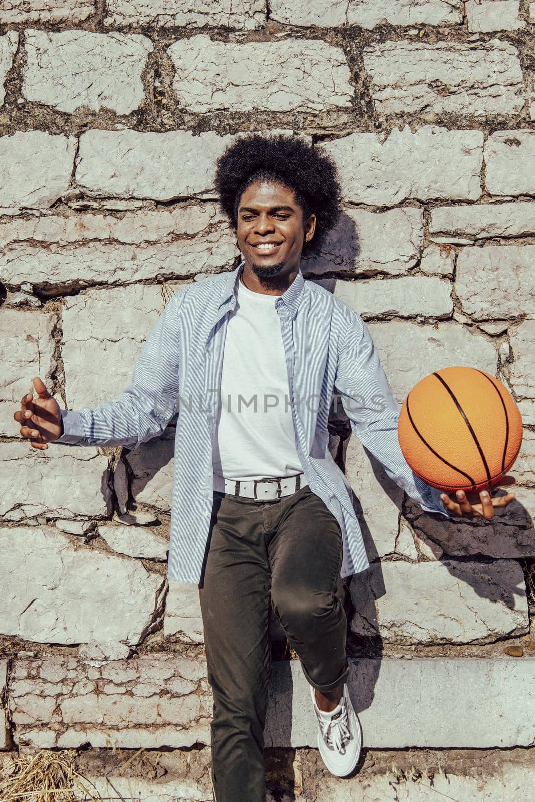 warm portrait of african american afro man with basket ball over wall