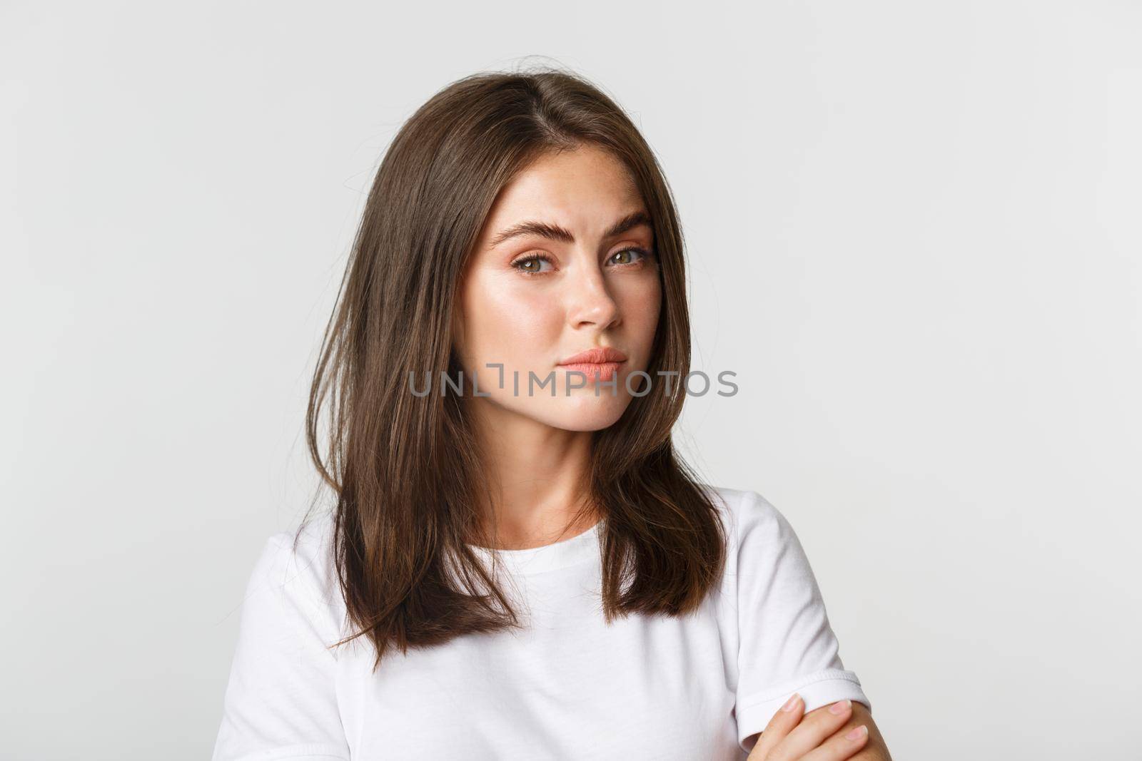 Close-up of attractive brunette girl looking skeptical and unamused.