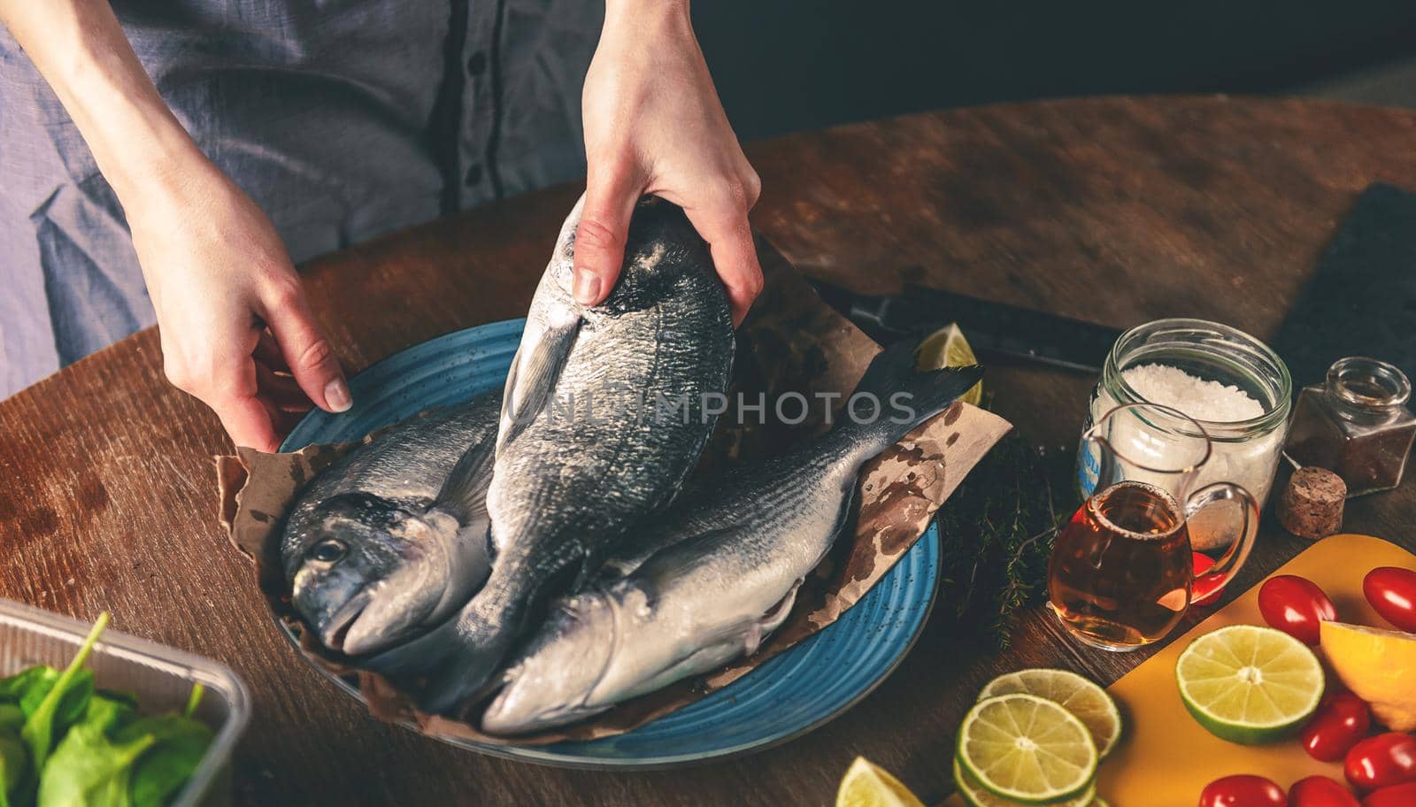 woman chef preparing fresh raw dorado fish