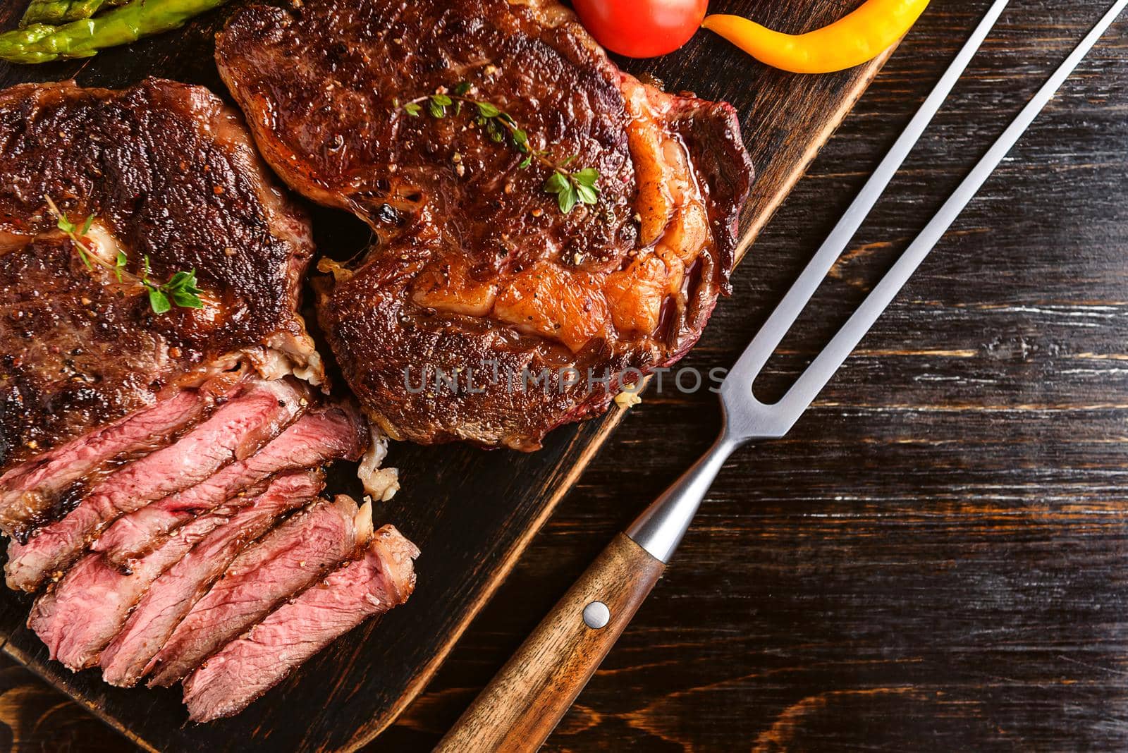 Dinner for two juicy delicious steaks, asparagus with parmesan and vegetables.