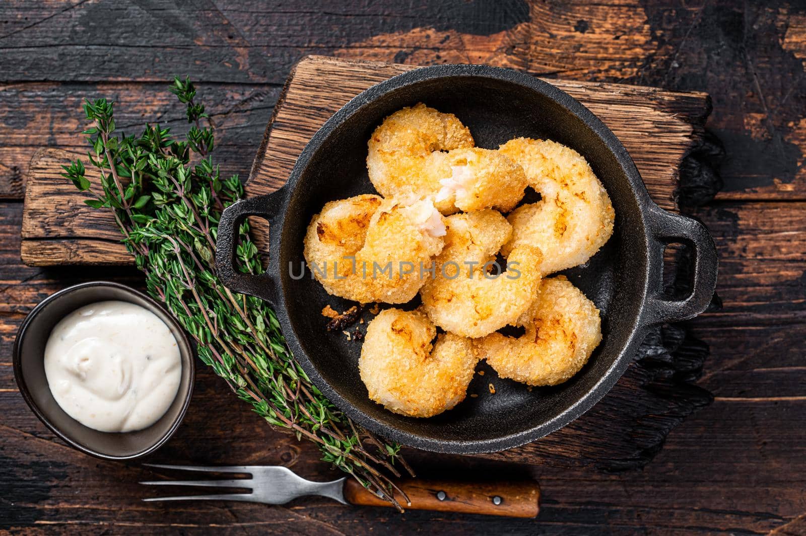 Fried Breaded Shrimps Prawns in a pan. Dark wooden background. Top view.