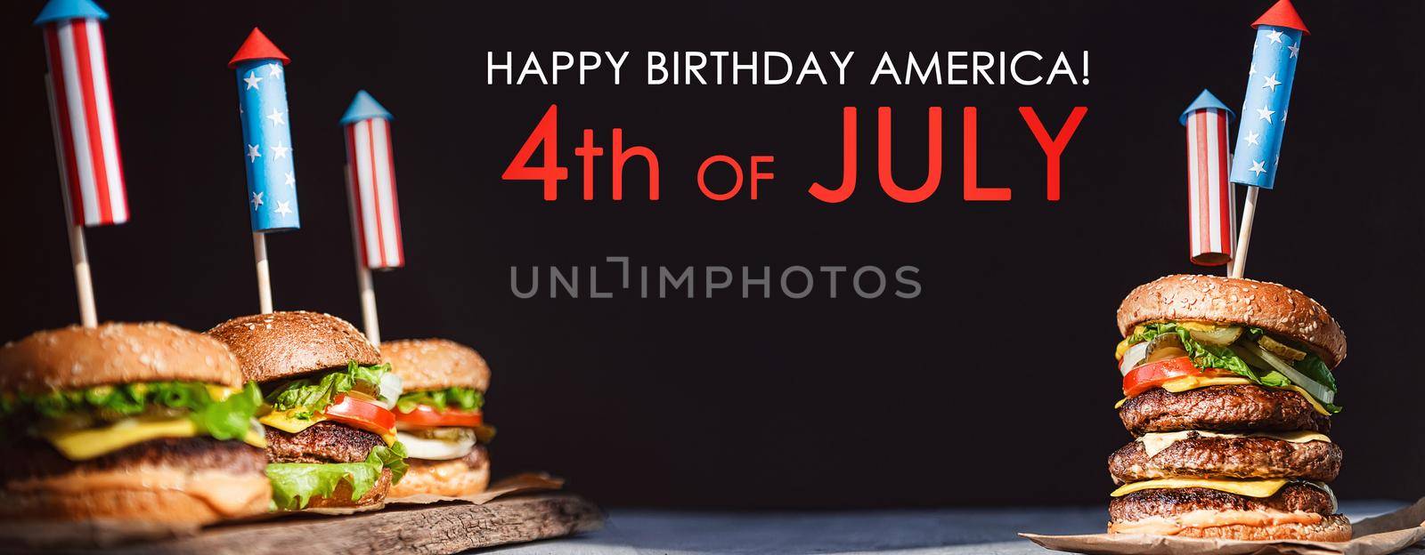 three fresh and juicy burgers with American flag-style fireworks inserted into them. bbq concept picnic to celebrate independence day by vvmich