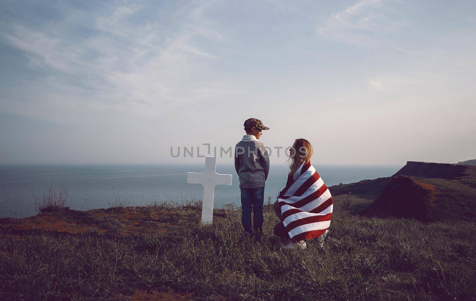 mother with son in the cemetery near the grave of the father of the American soldier who died in the ridge point defending the sovereignty and independence of the United States of America