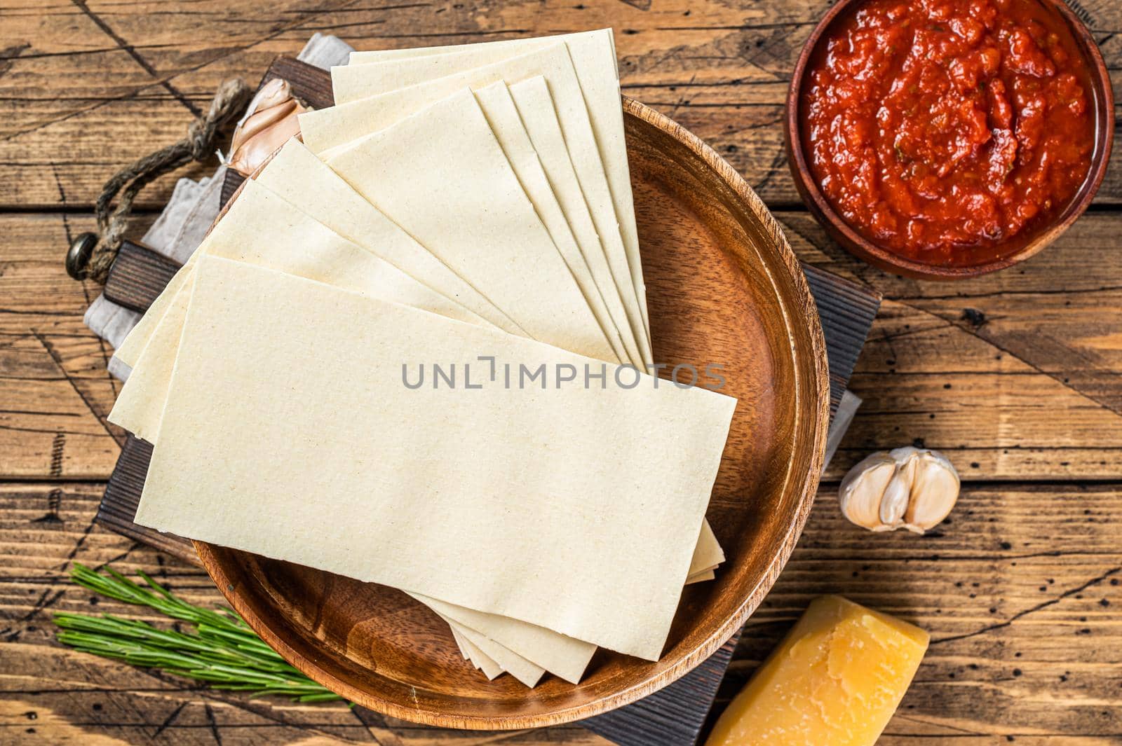 Set of ingredients for cooking lasagna close-up of Tomato sauce, pasta, cheese. wooden background. Top view.