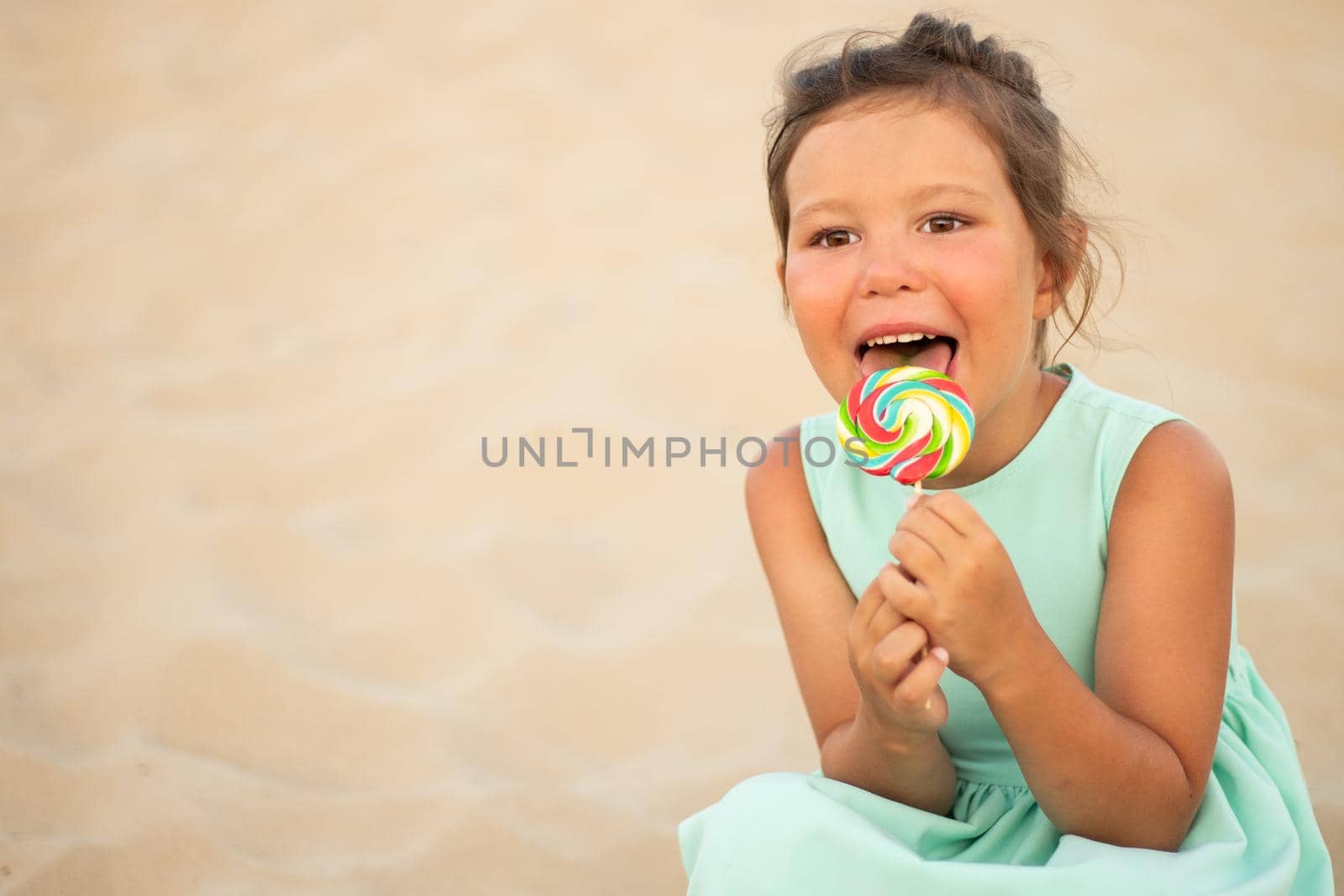 Cute little girl with big colorful lollipop. Child eating sweet candy bar. Sweets for young kids. Summer outdoor fun. by alf061