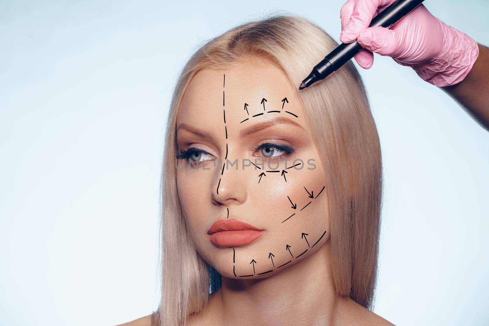 Beautiful blonde woman with markings for plastic surgery on her face, woman portrait