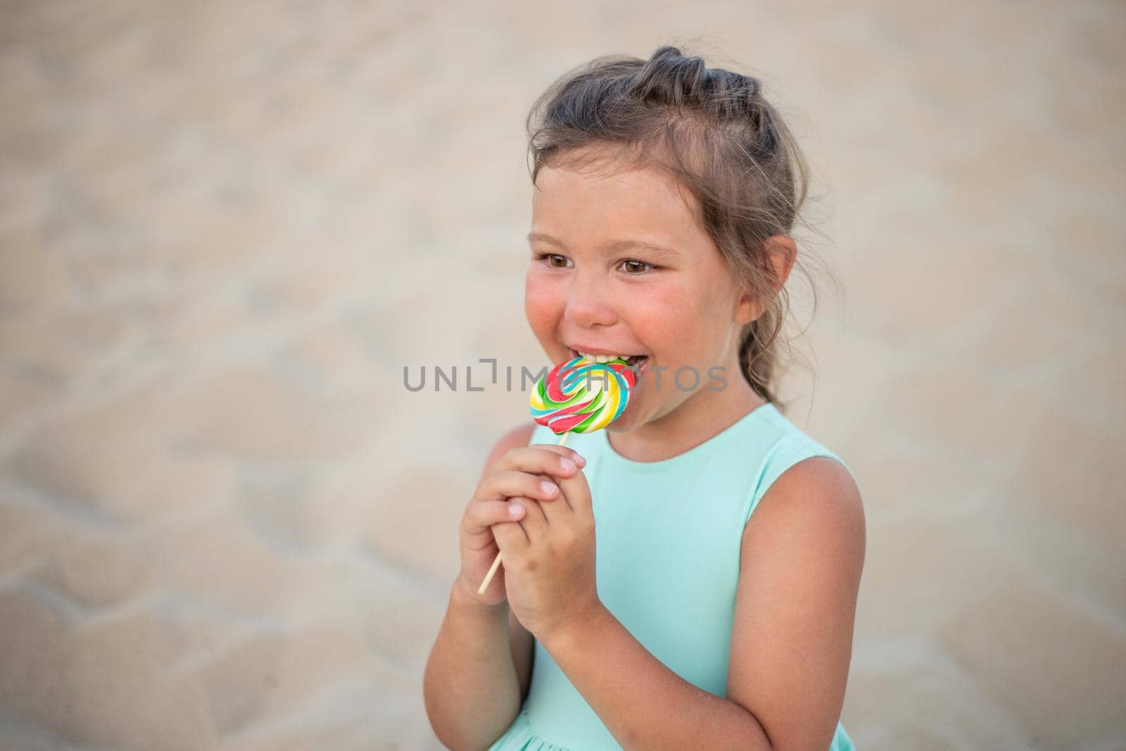 Cute little girl with big colorful lollipop. Child eating sweet candy bar. Sweets for young kids. Summer outdoor fun