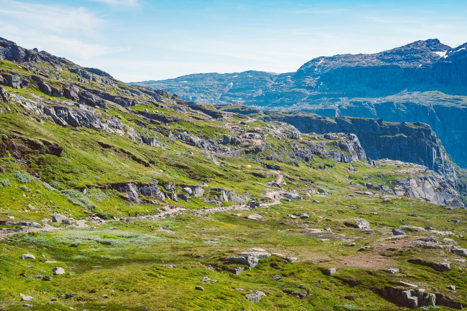 July 26, 2019. Norway tourist route on the trolltunga. People tourists go hiking in the mountains of Norway in fine sunny weather to thetrolltunga. Hiking backpack theme by Tomashevska