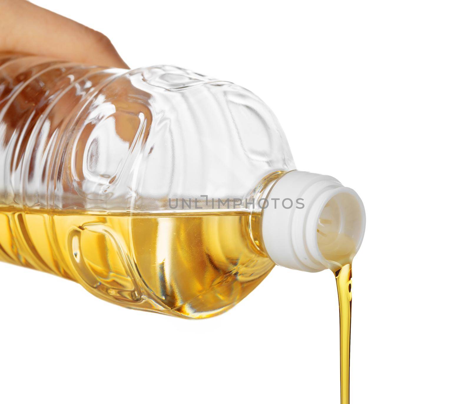 Hand of woman pouring cooking oil from plastic bottle. Isolated on white background. Close up.