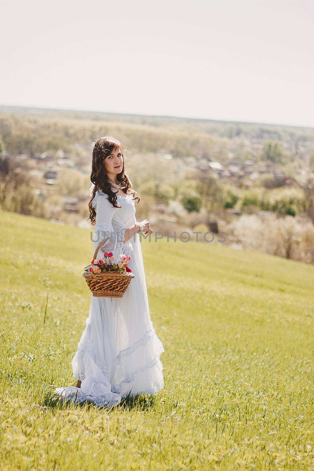 Portrait of carefree young woman in white vintage wedding style dress in spring cherry blossom garden valley by mmp1206