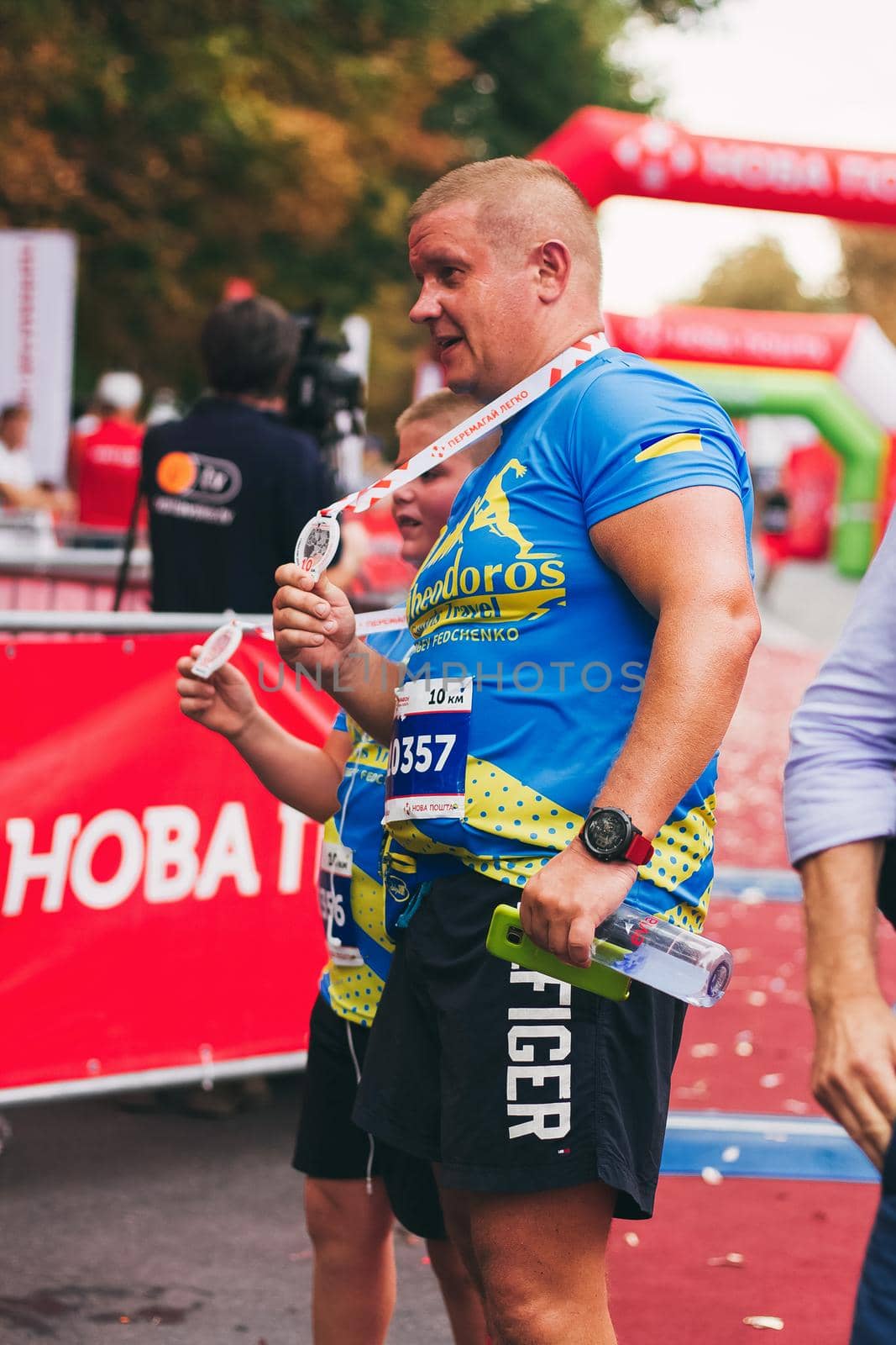 POLTAVA, UKRAINE - 1 SEPTEMBER 2019: A man with a son show medals during Nova Poshta Poltava Half Marathon.