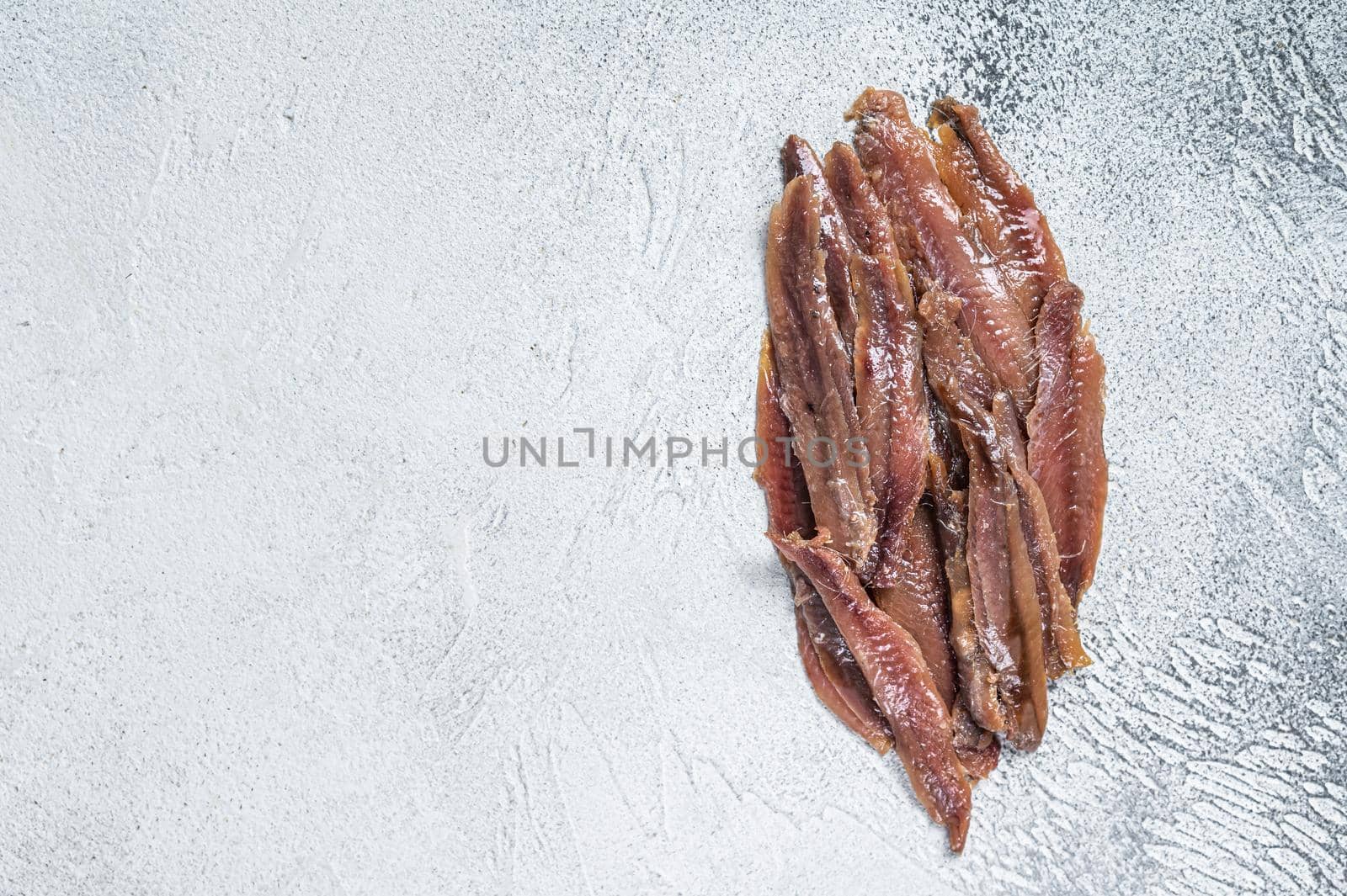 Canned Anchovies fish fillet in Olive Oil. White background. Top view. Copy space.