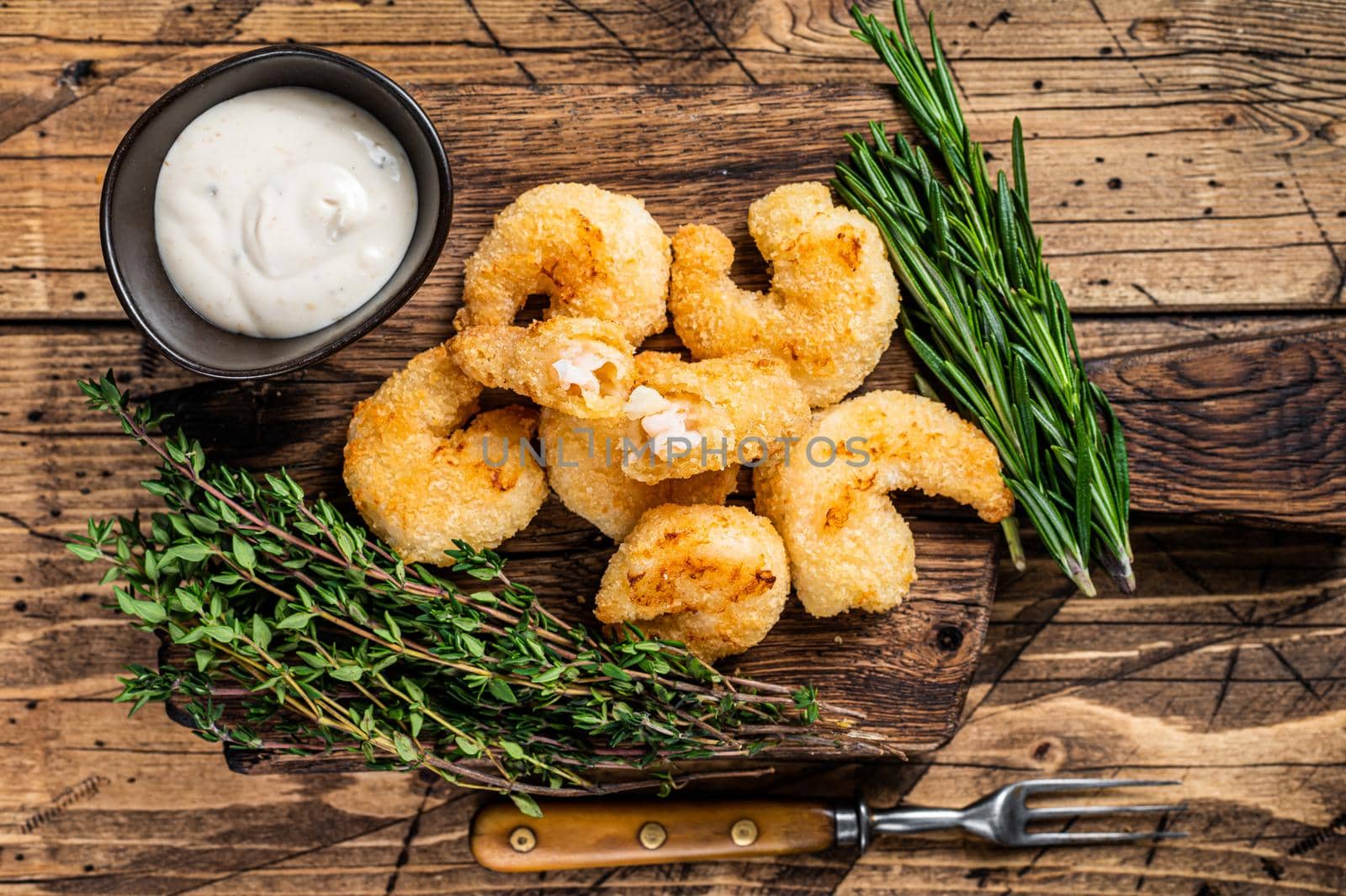 Fried Crispy Shrimps Prawns on a wooden board with sauce. wooden background. Top view.