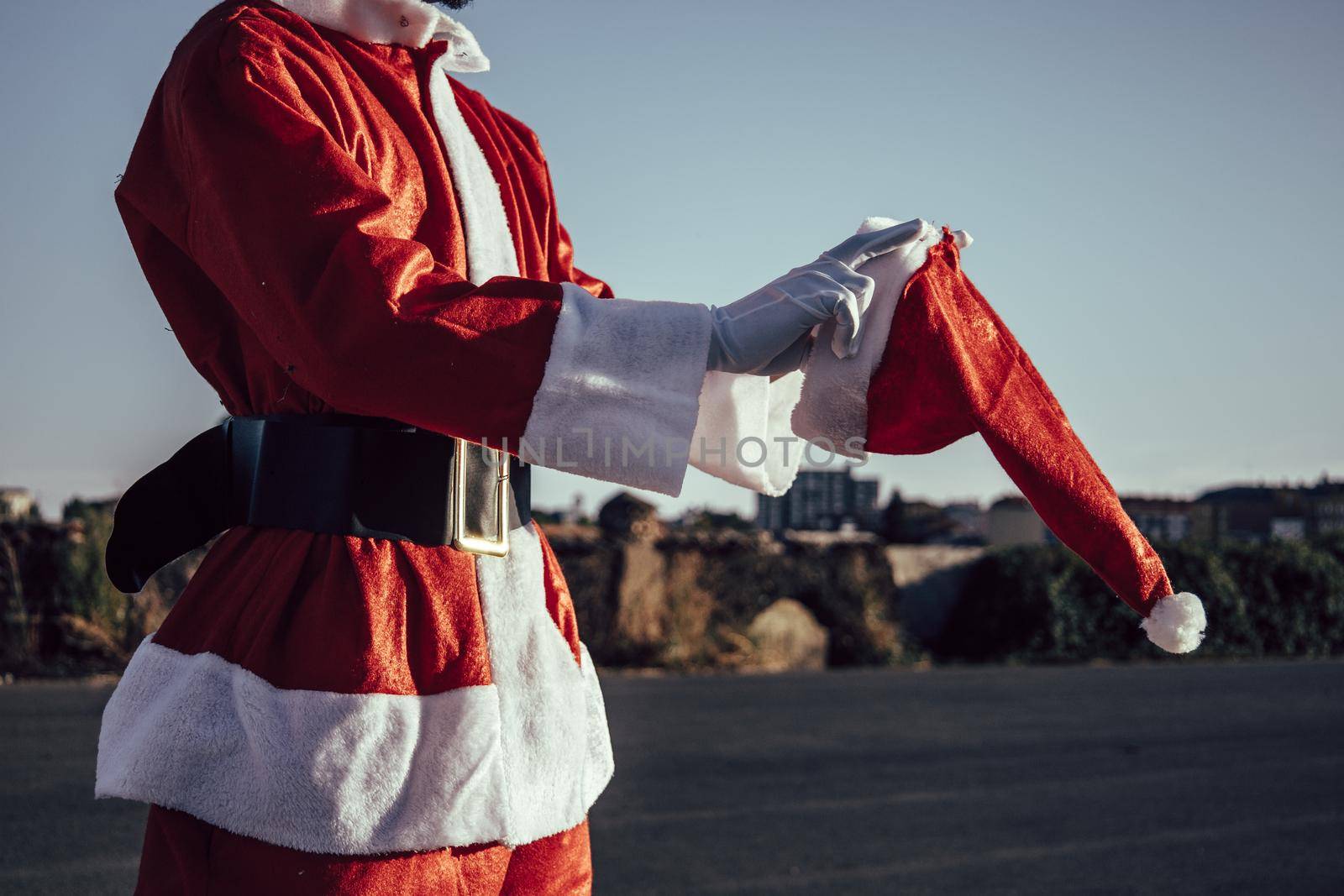 unrecognizable santa claus putting his santa hat on