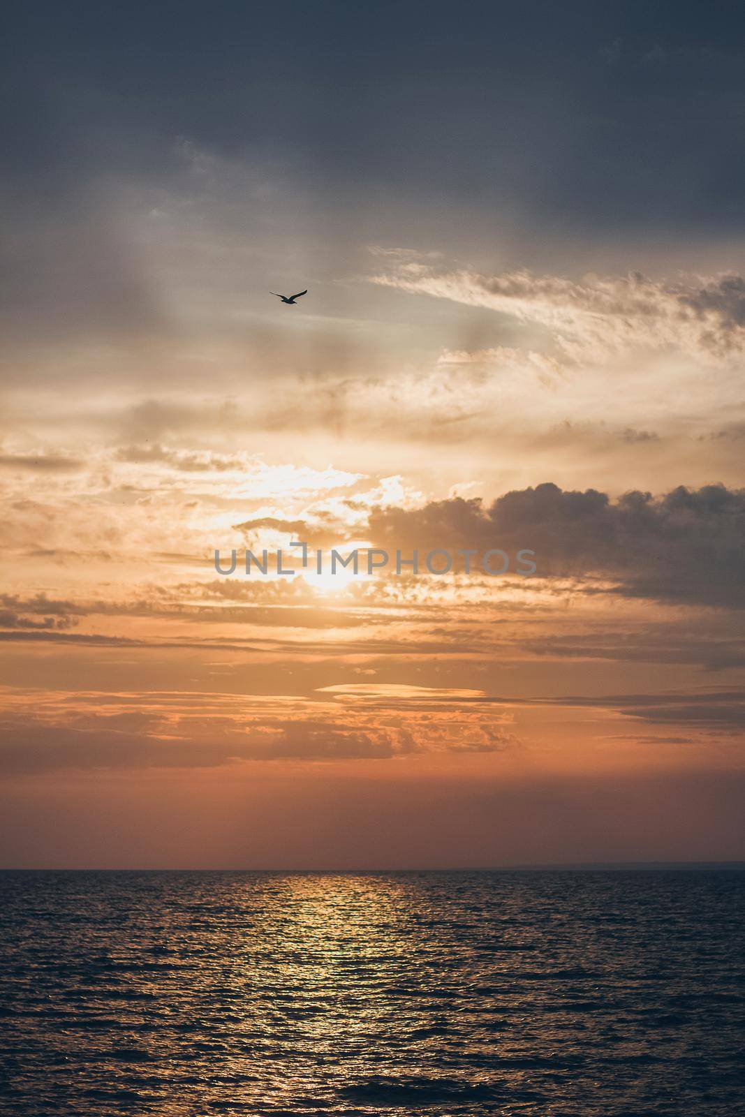 Sunrise sunset with beautifukls clouds and rays of light at the sea.