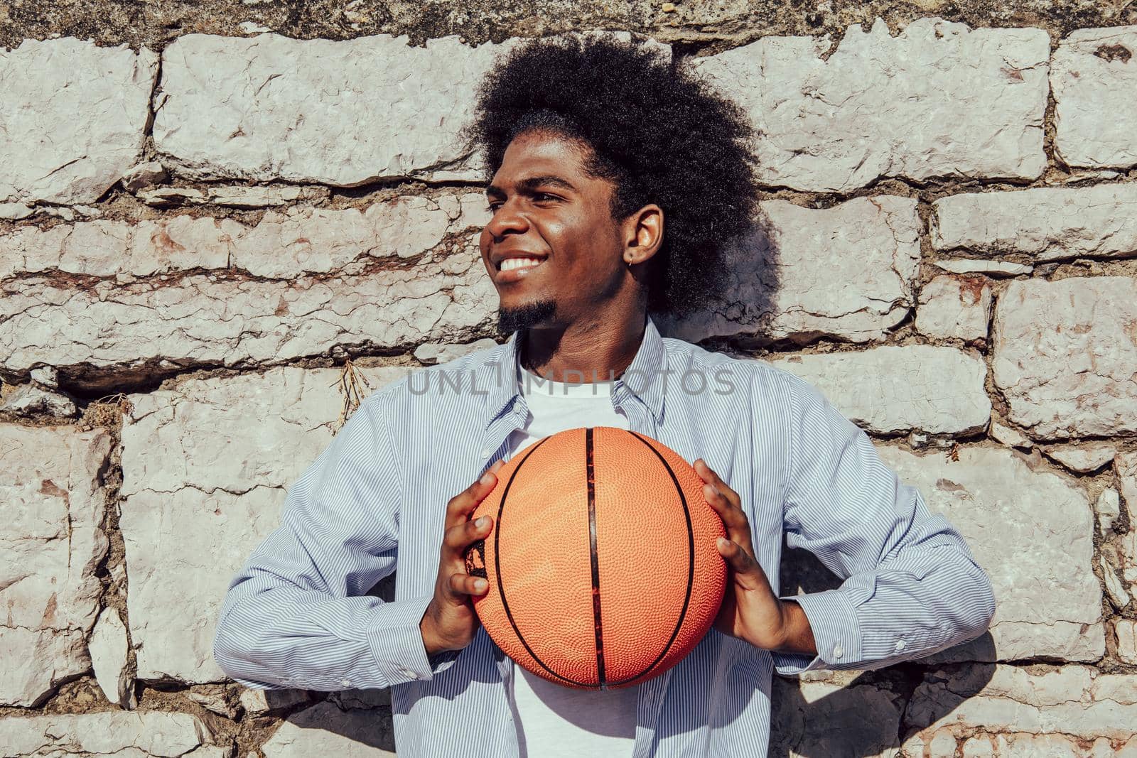 portrait of afro man with basket ball over stone background by ALVANPH