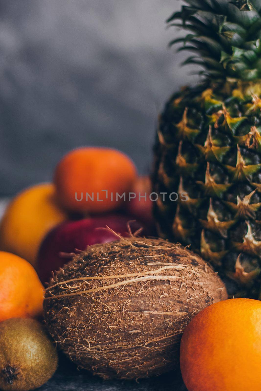 Colorful fresh tropical fruits on grey concrete background.