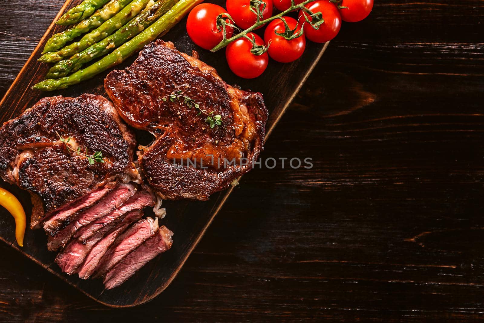 Dinner for two juicy delicious steaks, asparagus with parmesan and vegetables. by vvmich