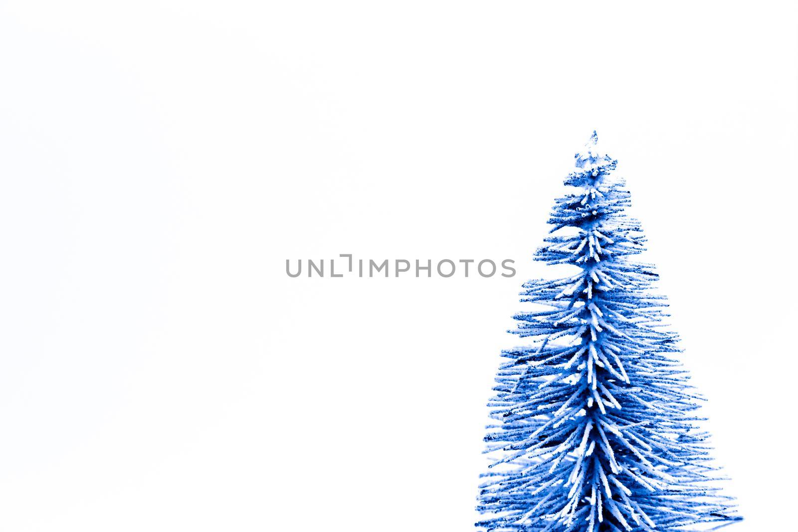 Trendy classic blue Christmas tree on a white background with copy space for text.