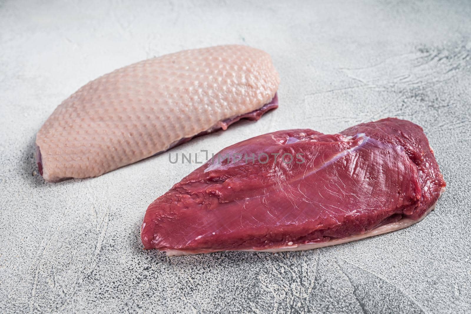 Raw uncooked Duck breast fillet steaks on butcher table. White background. Top View.