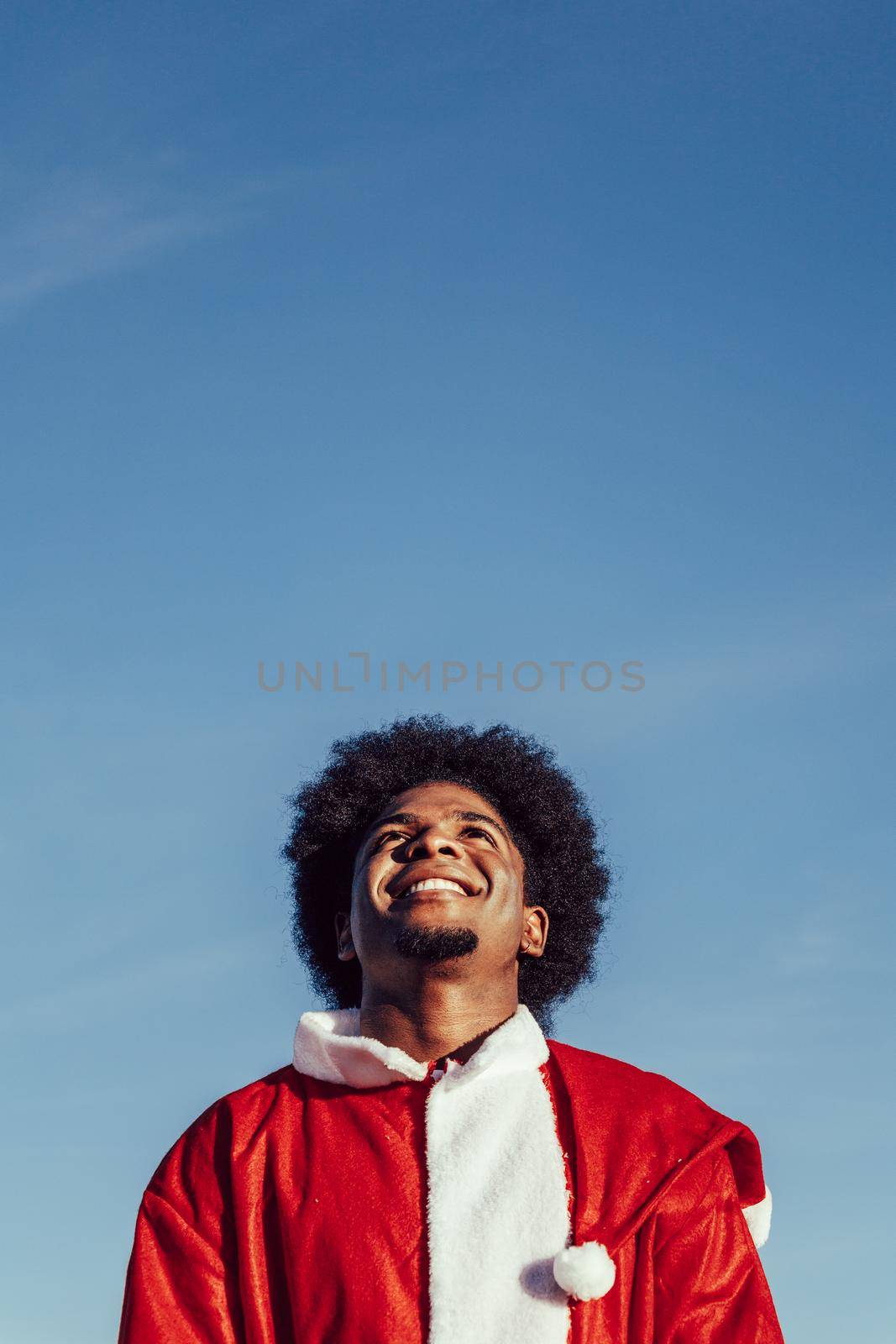 African american santa claus looking up over sky background
