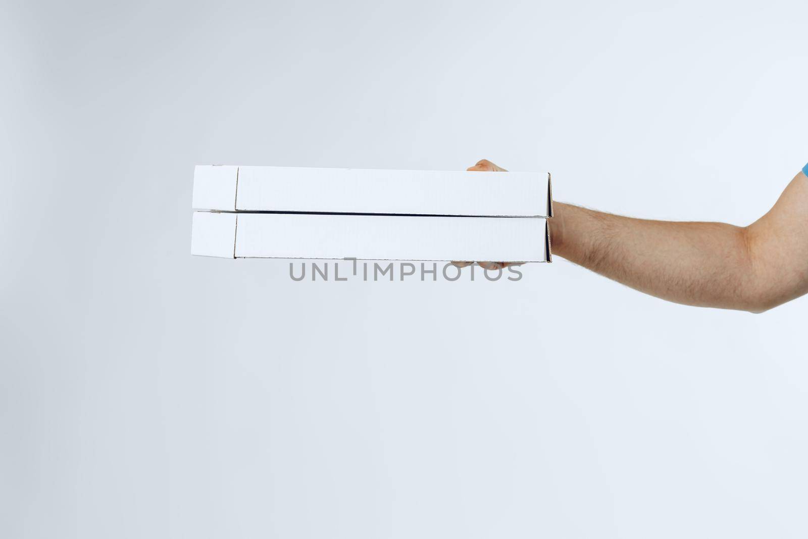 Courier hands giving packed food delivery close up against grey background