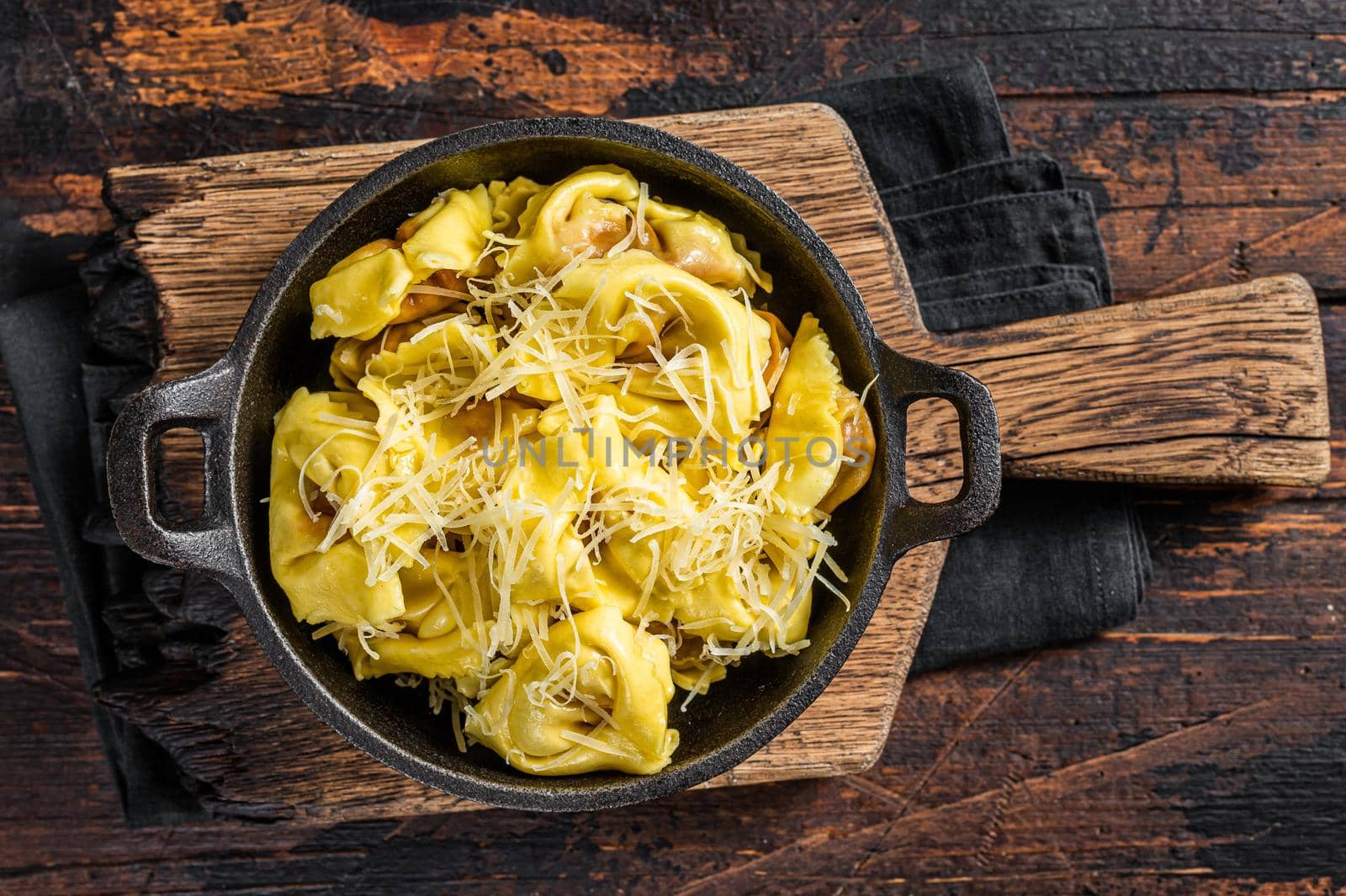 Ravioli Pasta with Mozzarella, parmesan cheese and Tomato. Wooden background. Top view.