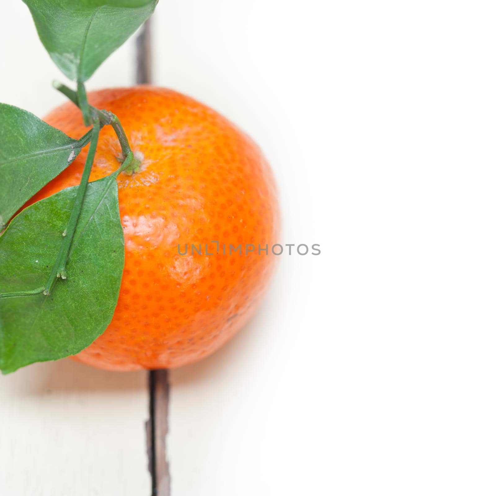 tangerine mandarin orange on white rustic wood table