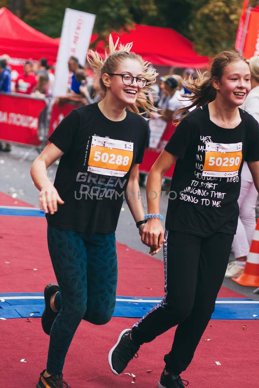 POLTAVA, UKRAINE - 1 SEPTEMBER 2019: Two teenage girls reachefinish line during Nova Poshta Poltava Half Marathon.