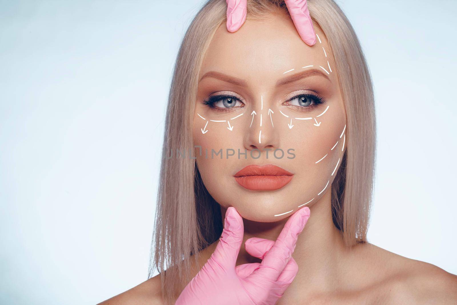 Portrait of attractive woman with arrows on her face skin for cosmetology