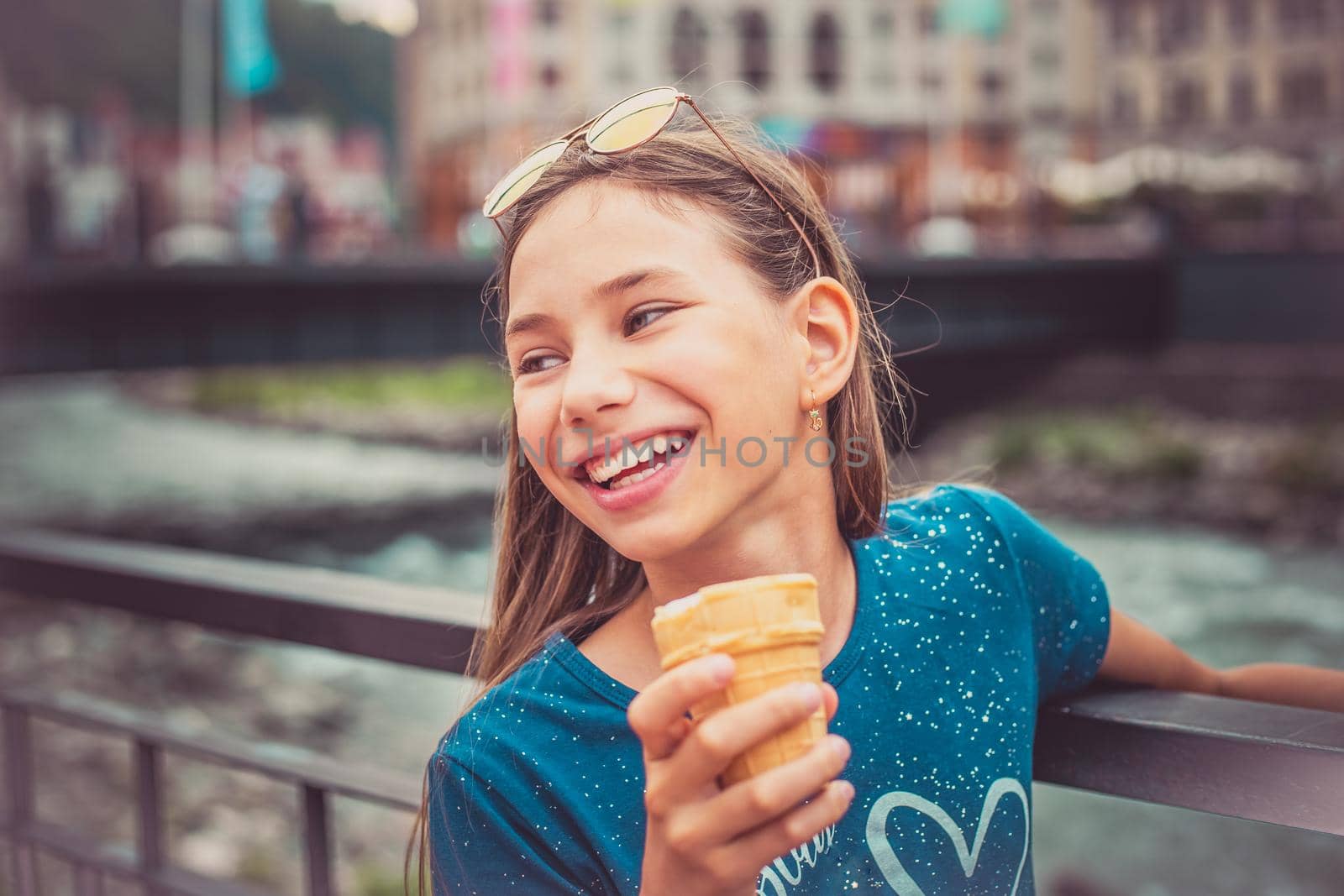 Portrait of a happy child with ice cream in hands on a city street. by alf061