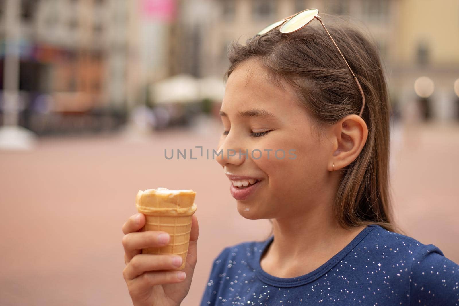 Portrait of a happy child with ice cream in hands on a city street