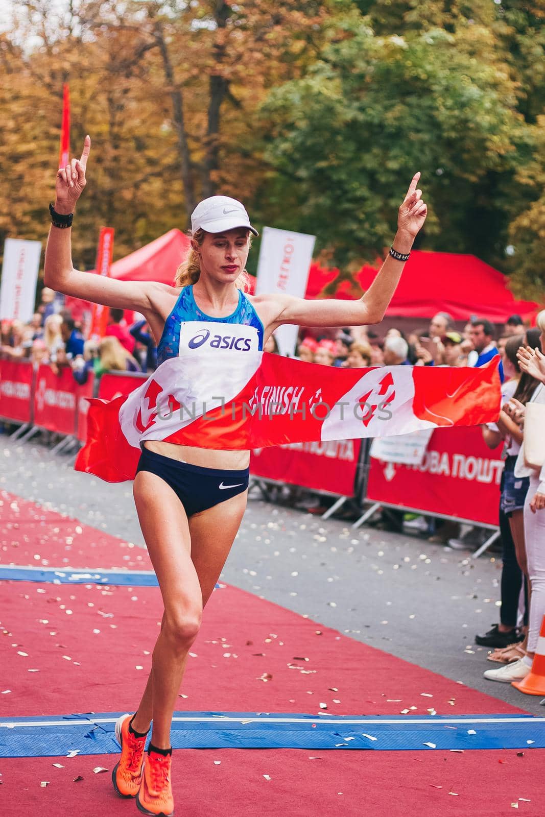POLTAVA, UKRAINE - 1 SEPTEMBER 2019: A young woman reaches finish line during Nova Poshta Poltava Half Marathon by mmp1206