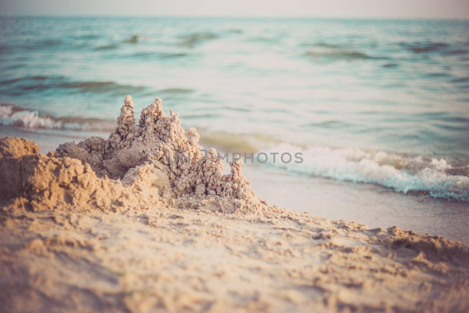 Sand castle standing on the beach. Travel vacations concept