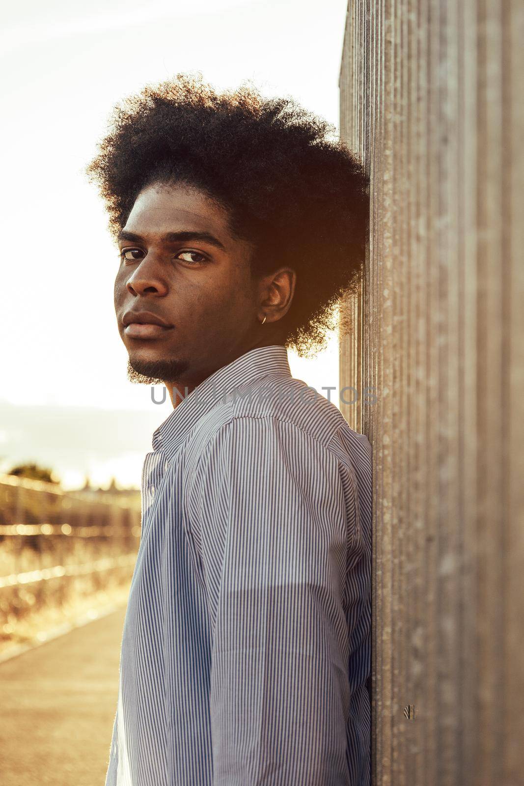 Vertical portrait of serious man leaning on wall looking to the camera