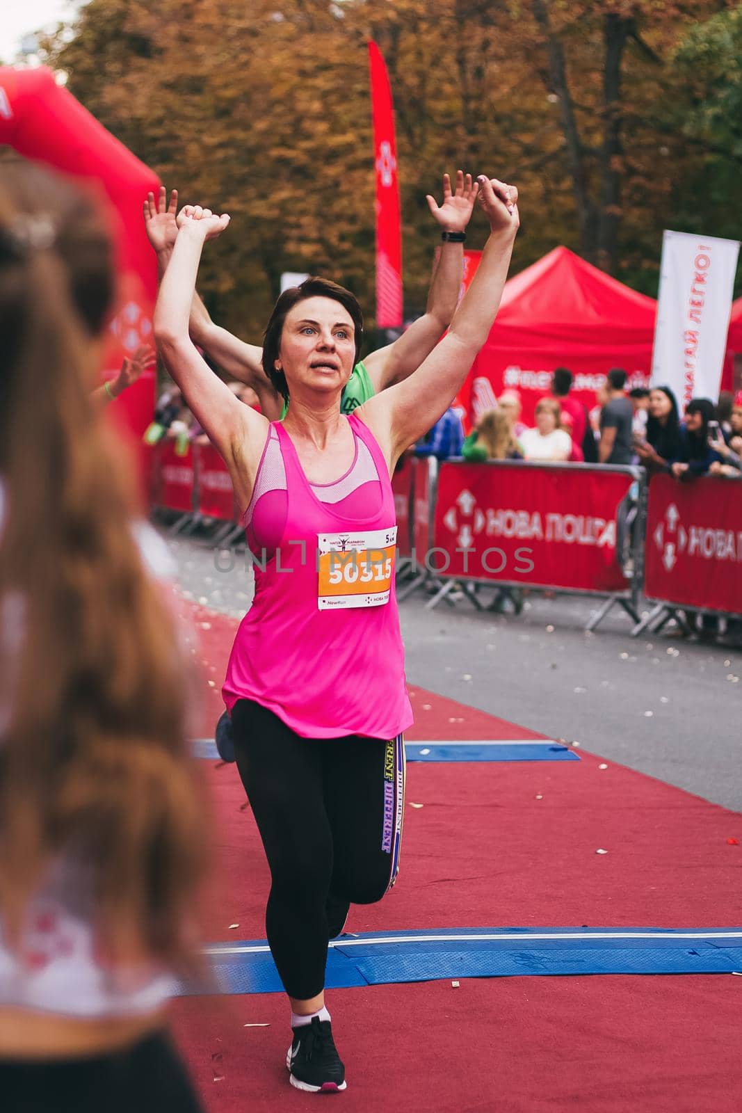 POLTAVA, UKRAINE - 1 SEPTEMBER 2019: A mature woman reaches finish line during Nova Poshta Poltava Half Marathon.