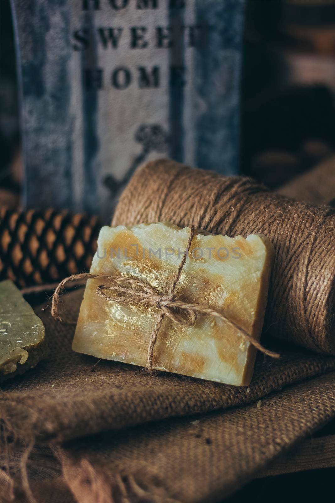 Pieces of beautiful natural handcrafted soap on wooden background with botanical elements, close up view. For relax, health, spa and aromatherapy