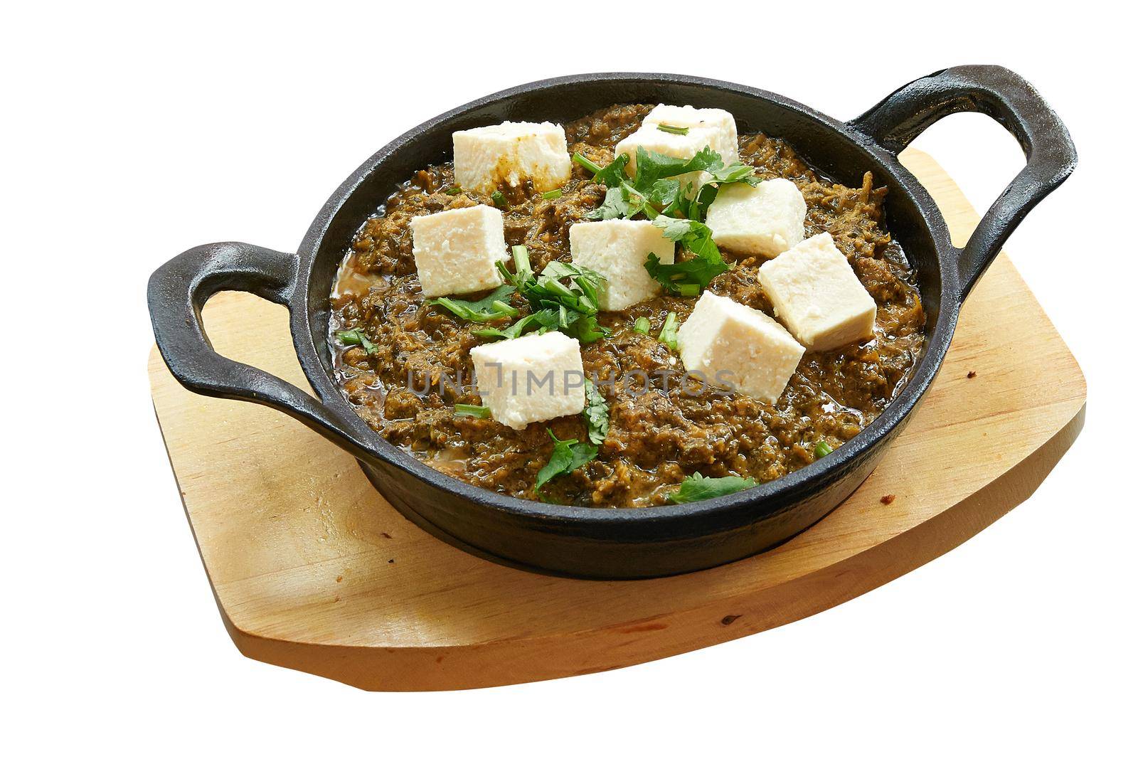 Overhead  shot of Palak paneer baked in little pan. by pbombaert