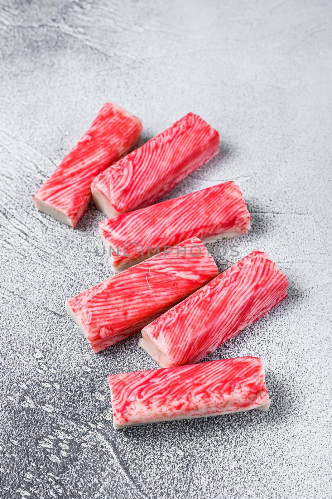 Crab surimi sticks on kitchen table. White background. Top view.