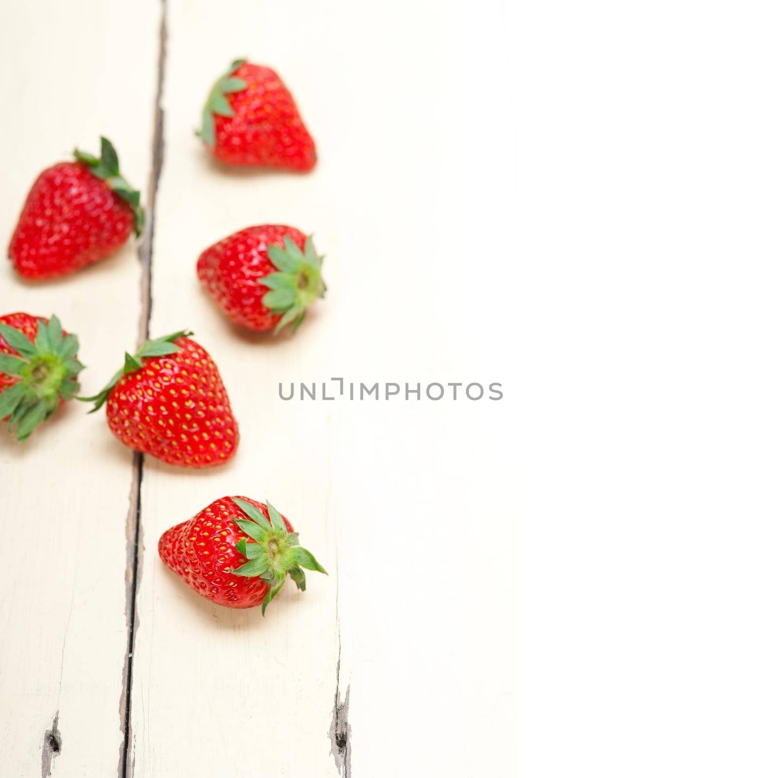 fresh organic strawberry over white wood by keko64