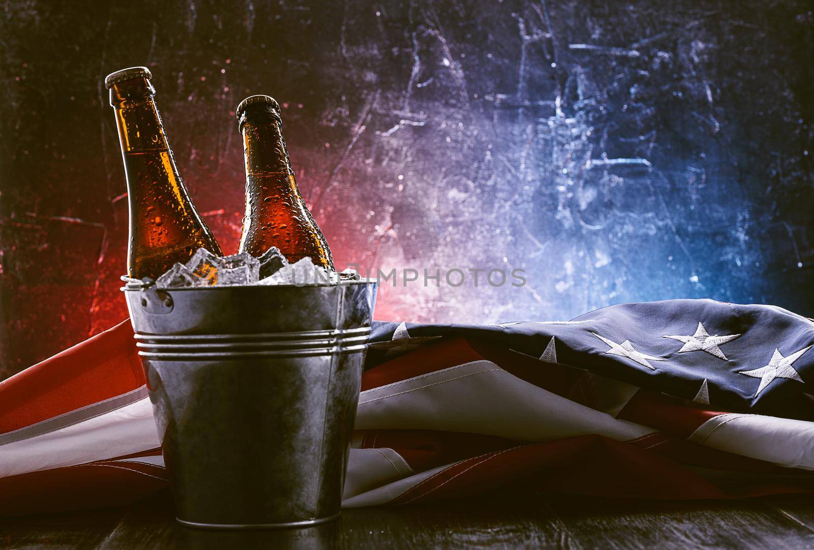 two bottles of beer in an ice bucket with the American flag lying nearby. Independence Day celebration concept by vvmich