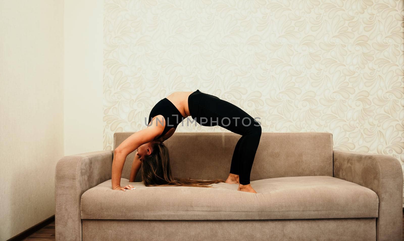 Young woman with long hair, fitness instructor in black sportswe by panophotograph