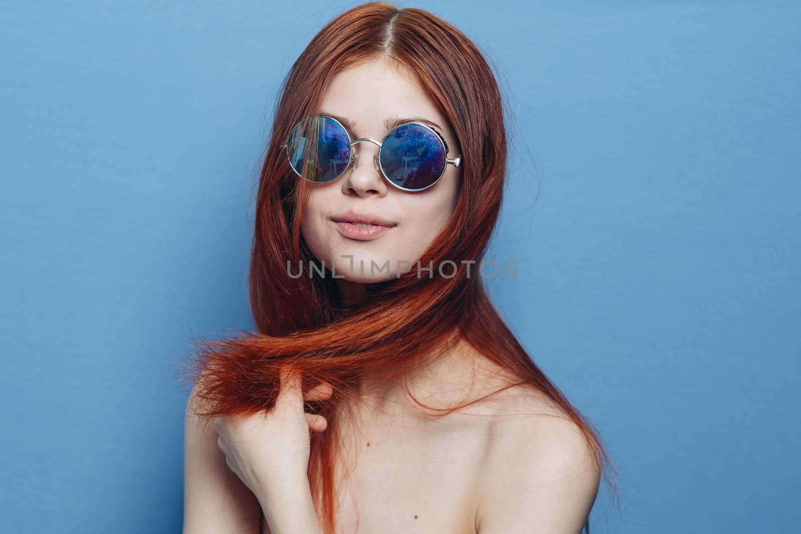 attractive woman with bare shoulders fashionable glasses blue background. High quality photo