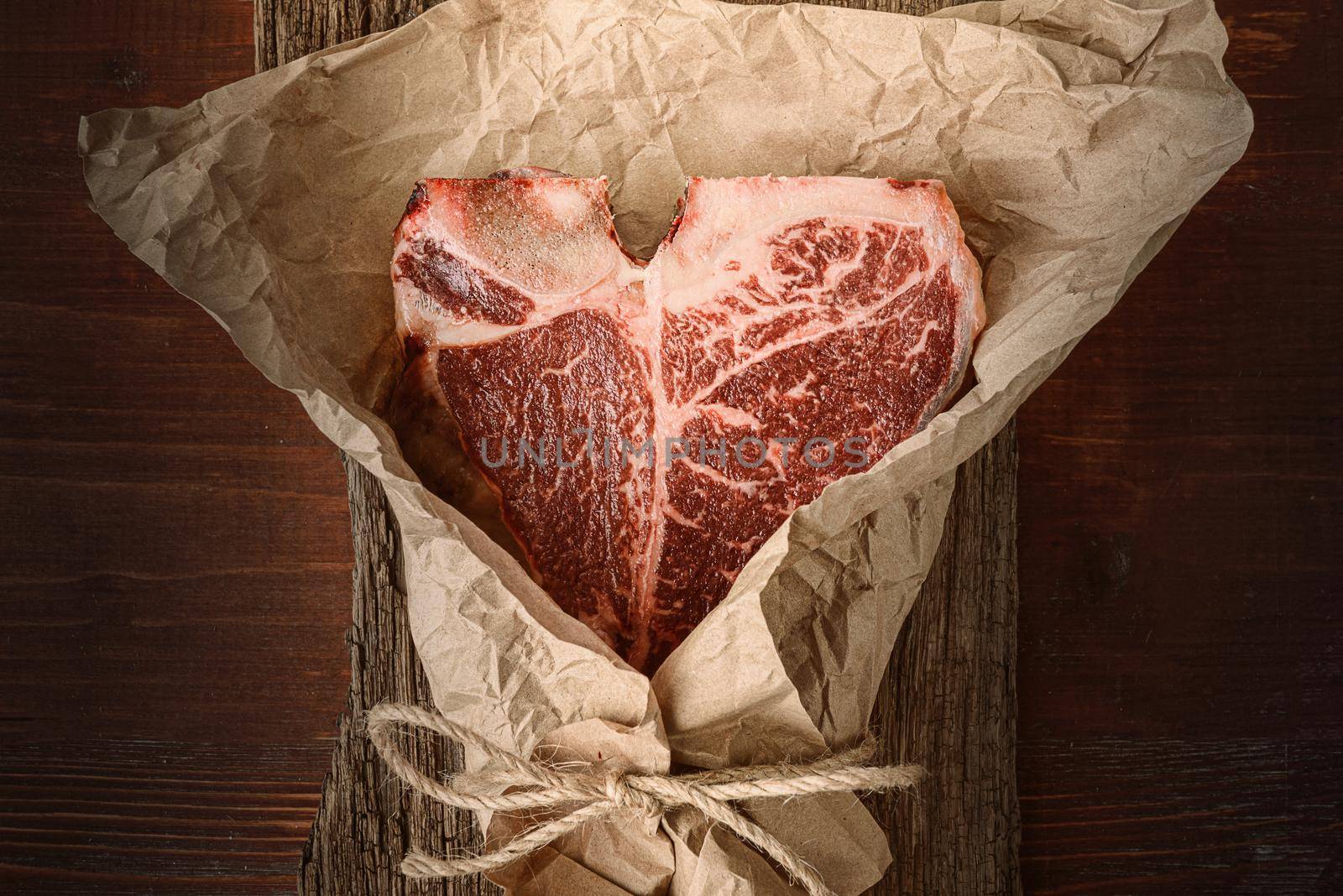 a piece of fresh farm meat t-bon non-GMO wrapped in eco-friendly wrapping paper by vvmich