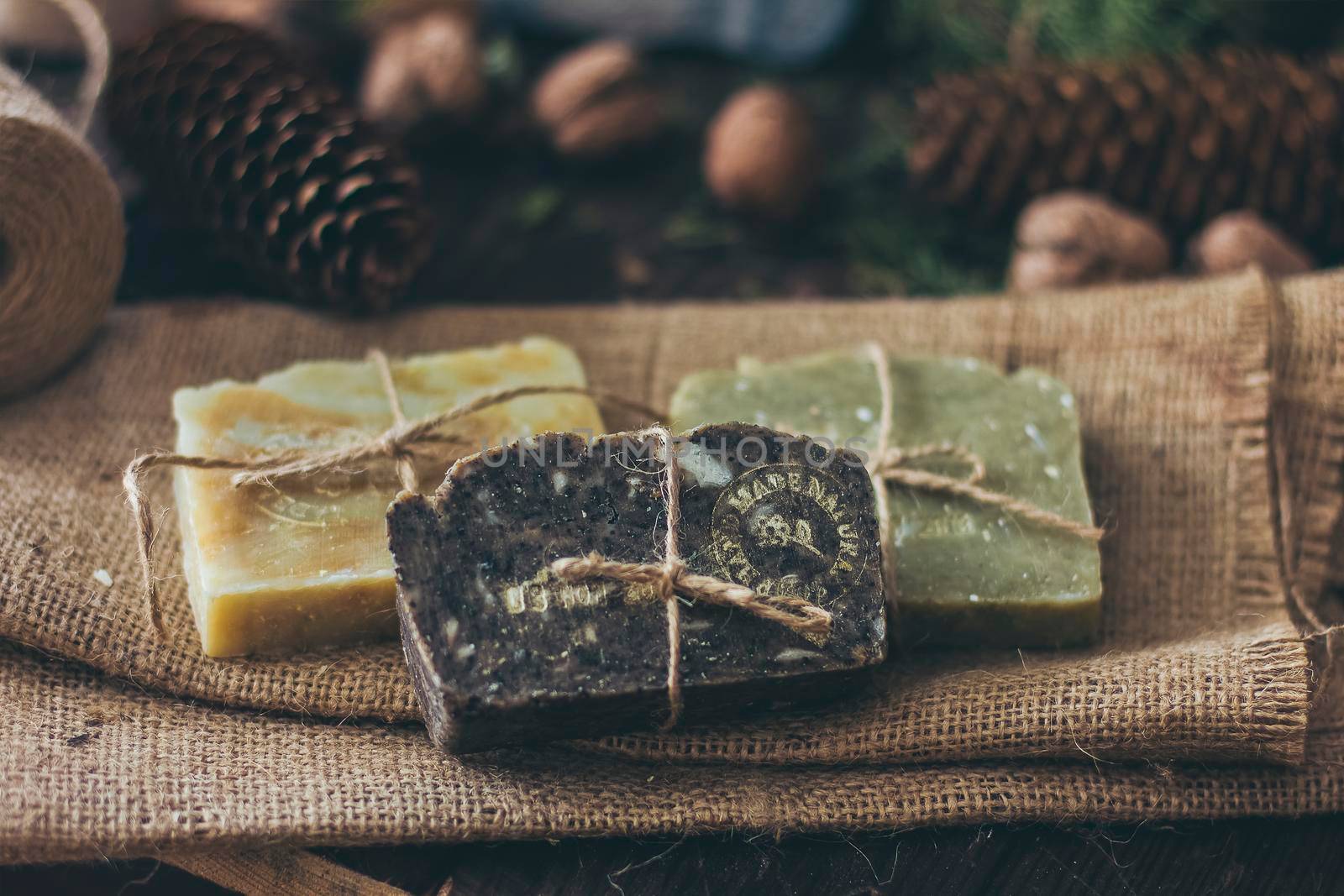 Pieces of beautiful natural handcrafted soap on wooden background with botanical elements, close up view. by mmp1206